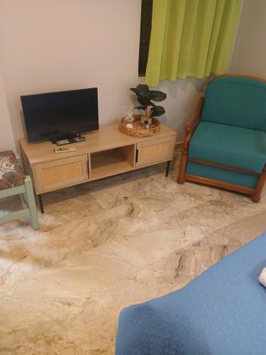 a living room with a tv and a chair at Studios Μιχαλαρεα in Kyparissia
