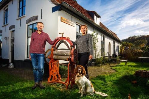 two men and a dog standing next to a machine at B&B Wasboerderij Beek Ubbergen in Beek