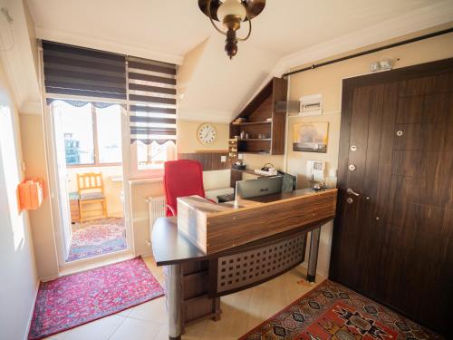 a kitchen with a wooden desk and a red chair at Downtown Bayrak Residences Trabzon in Trabzon