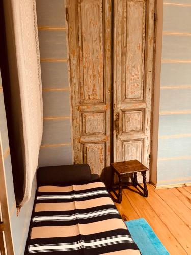 a couch in a room with a door and a table at Dzveli Galavani -Old Wall in Tʼelavi