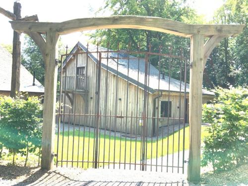 a gate in front of a wooden building at Au Charme de Rachamps - 4 personnes in Bastogne
