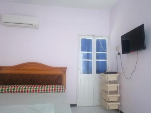 una camera da letto con un letto, una televisione e una finestra di Loyalty apartment a Dumyat al Jadidah