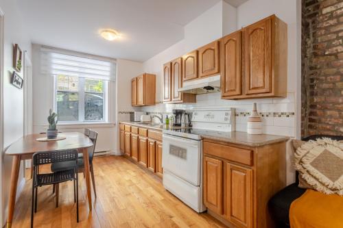 a kitchen with wooden cabinets and a table and a table and a chair at Elegant 4 Bedroom residence in downtown MTL in Montréal