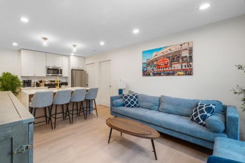 a living room with a blue couch and a kitchen at 1 Bedroom with Rooftop and Wrigley Views in Chicago