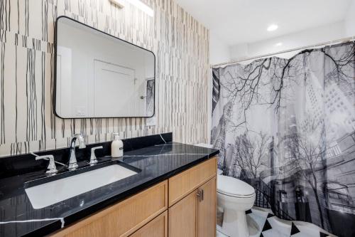a bathroom with a sink and a toilet and a mirror at 1 Bedroom with Rooftop and Wrigley Views in Chicago