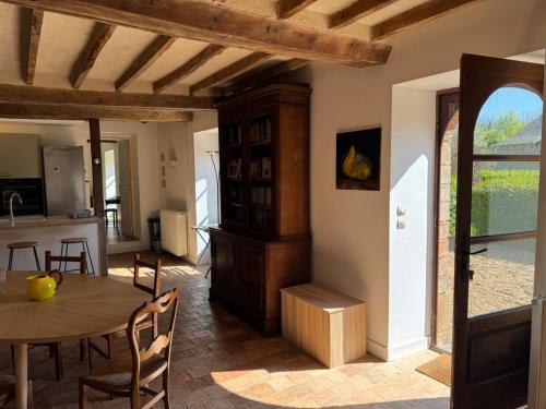 a kitchen and a dining room with a table at Charmant corps de ferme réhabilité en Mayenne in Daon