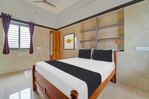 a bedroom with a bed and a window at Super Hotel O Jaganath Nagar Near Hopes College in Coimbatore
