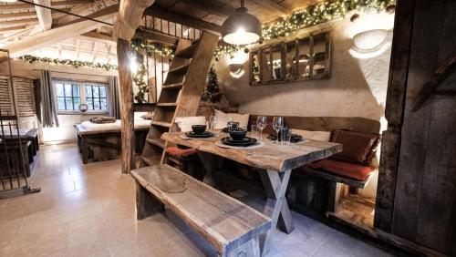 a dining room with a wooden table and a bench at Au Charme de Rachamps - 4 personnes in Bastogne