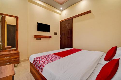 a bedroom with a red and white bed and a television at Hotel O The Honey Guest House in Haldwāni