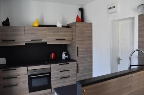 a kitchen with wooden cabinets and a stove top oven at Duplex 90 m2, Le Touquet, quartier Westminster 3 chambres, 6 couchages, 1 parking, Location à la semaine en juillet, août et pendant les semaines de vacances scolaires de fin d'année, sinon 2 nuits minimum in Le Touquet-Paris-Plage