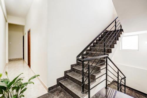 a staircase in a home with white walls and concrete floors at Super Townhouse Hennur Prakruthi Layout Bangalore in Bengaluru
