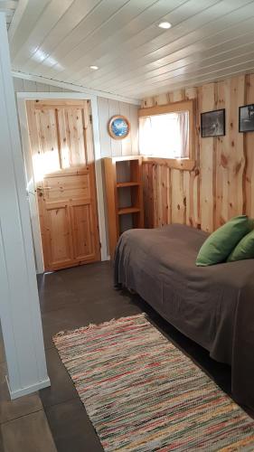 1 dormitorio con cama, ventana y alfombra en Torvløbakkan Gard, en Kvinesdal