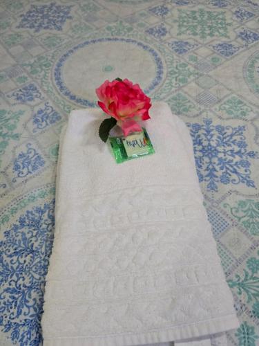 a rose sitting on top of a white towel at Pousada Casa de Buzios in Búzios