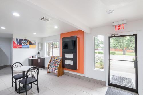 an exit sign in a room with a table and chairs at Motel 6-Grand Prairie, TX - Near Six Flags Drive in Grand Prairie