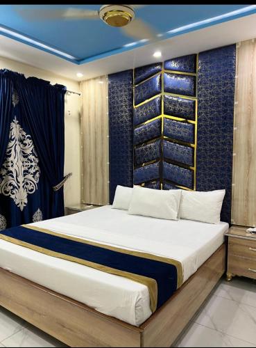 a bedroom with a large bed and a blue wall at Hotel new royal palace in Lahore