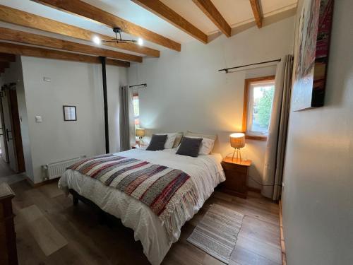 a bedroom with a bed and a window at Hostel Torobayo in Valdivia
