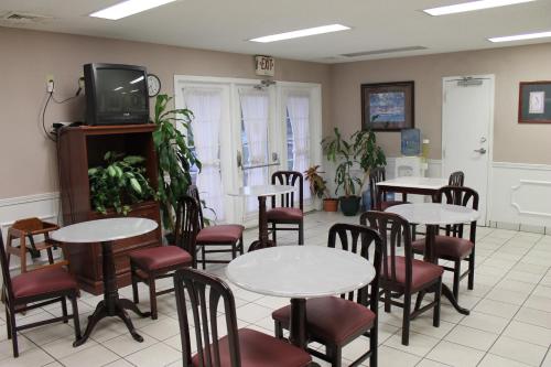 a dining room with tables and chairs and a tv at American Motel - Lenoir in Lenoir