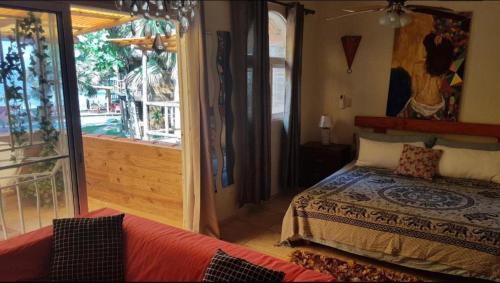 a bedroom with a bed and a large window at Cabarete Ecolodge Encuentro Surf Beach Kite in Perla Marina by BTCG Crypto in Bombita