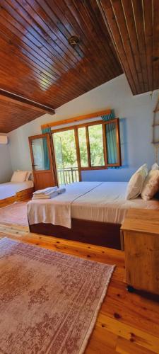 a bedroom with two beds and a wooden ceiling at Ahsen pansiyon in Selçuk