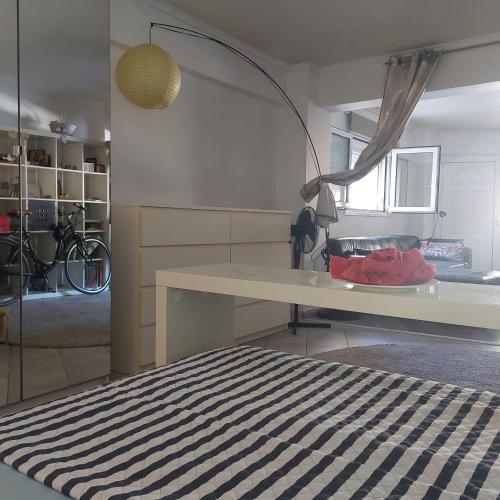 a room with a bed and a table and a room with a bike at LOBBY comfort studio in Thessaloniki