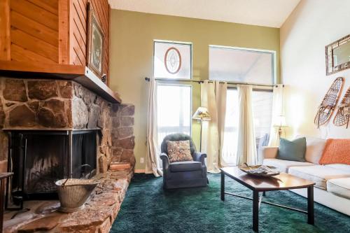 a living room with a couch and a stone fireplace at Family Fun Condo - 2bdrm with Loft Perfect for 6 in Fraser