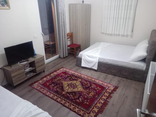 a room with two beds and a tv and a rug at anjel home in Piskupat