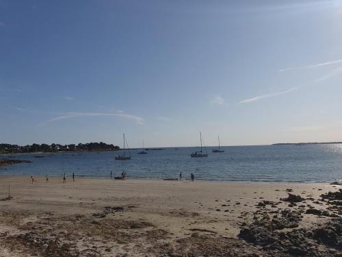 a group of people on a beach with boats in the water at Apartment in Passage on GR34 in Concarneau