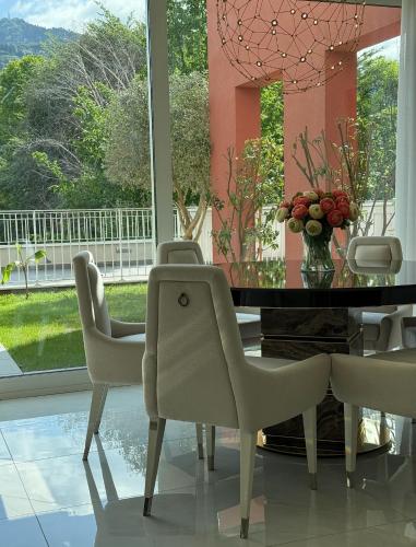 a dining room with white chairs and a table and a window at Borgo Vico Luxury Suites in Como