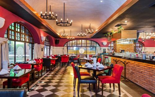 a restaurant with tables and chairs and a bar at Casa del Balam Merida in Mérida