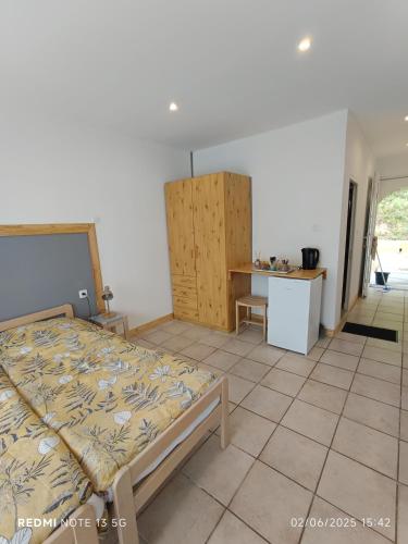 a bedroom with a bed and a desk in it at Le clos des Romarins Chambre JONQUILLE in Belmontet
