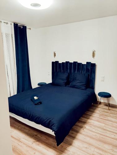 - une chambre avec un lit avec des draps bleus et une table dans l'établissement Grande villa moderne, à Moyrazès