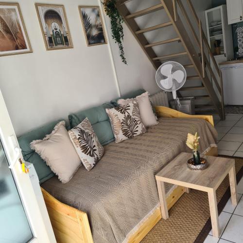 un canapé avec des oreillers et une table dans une pièce dans l'établissement Kedge 5 - proche centre, tram & universités, à Talence