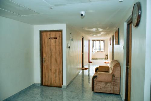 a hallway with a couch and a wooden door at MSVG Residency in Tirunelveli