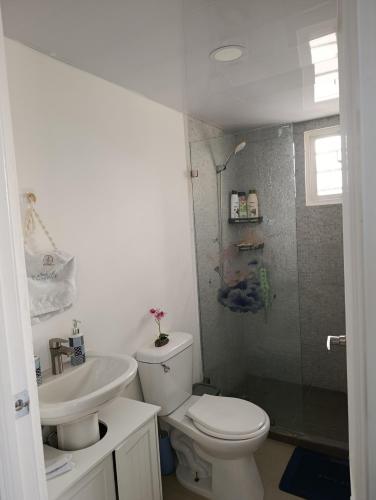 a white bathroom with a toilet and a sink at El descanso perfecto in El Cruce