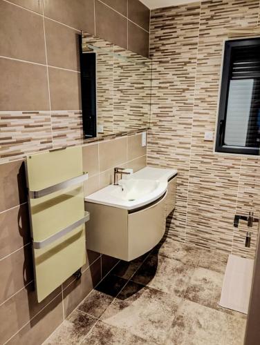 une salle de bain avec un lavabo et un miroir dans l'établissement Grande villa moderne, à Moyrazès