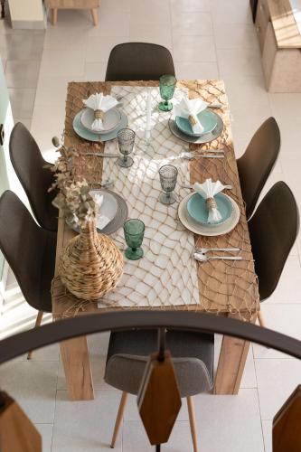 a dining table with plates and bowls on it at Villa Aelia Luxury Maisonette in Salamís