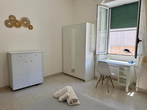 a room with a desk and a chair and a window at RM's Guesthouse in Brindisi