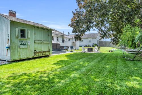 a backyard with a green house and a yard withgrass at Great Hammock Getaway in Old Saybrook