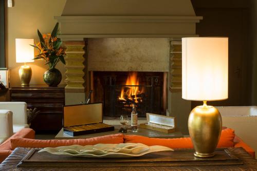 a living room with a fireplace and a table with a lamp at Casa Vissani in Baschi