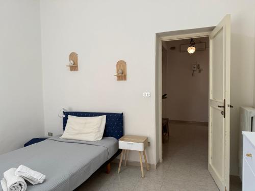 a small bedroom with a bed and a small table at RM's Guesthouse in Brindisi