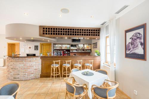 a kitchen with a table and chairs and a bar at Hotel Pavlov in Pavlov