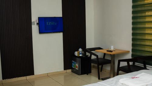a room with a table and a blue sign on the wall at Mende Hotel in Lagos