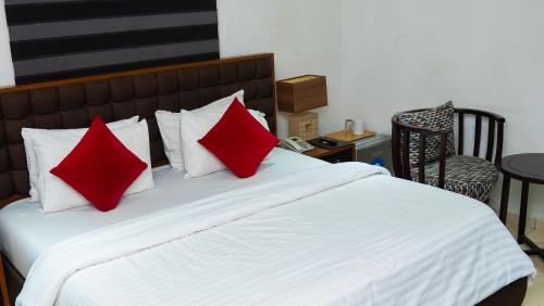 a bed with red and white pillows on it at Mende Hotel in Lagos
