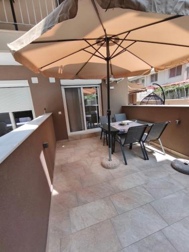 a patio with a table and an umbrella at Nina Lux Studio in Olympiaki Akti