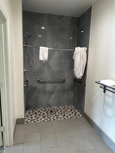 a bathroom with a shower with a tiled floor at Signature Inn North Houston District in Houston