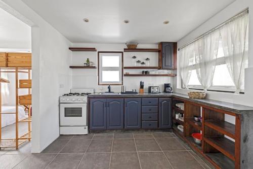 eine Küche mit blauen Schränken und einem Herd in der Unterkunft Charming Private Cottage in Gated Estate in Belmont