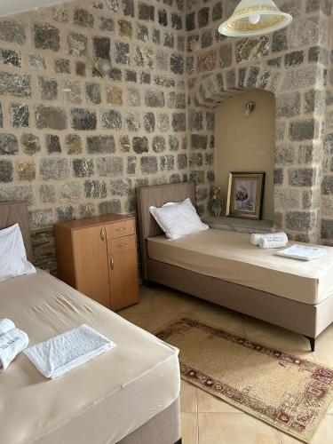 two beds in a room with a brick wall at Vila Nikola in Bratesici