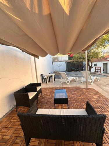 a patio with chairs and tables under a large umbrella at Pina House in Pêra