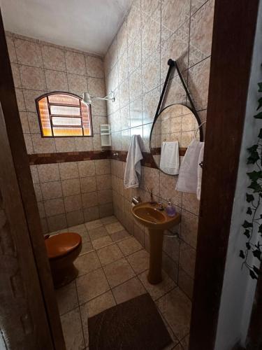 a bathroom with a sink and a toilet and a mirror at Residencial Divina in Pirenópolis