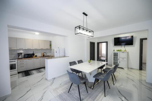 a kitchen and dining room with a white table and chairs at Casa Timiș in Vişeu de Sus